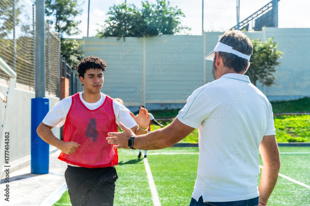 Fototapeta premium Soccer coach mentoring young player during training