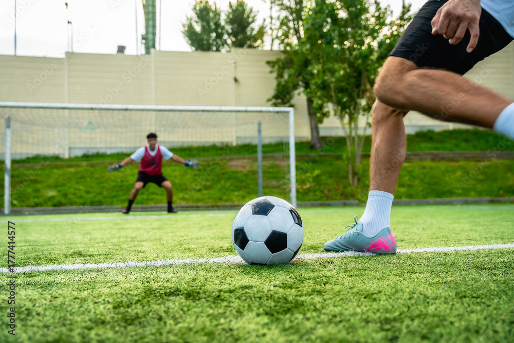Obraz premium Football player taking penalty kick against goalkeeper