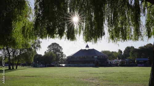 The Embankment Pub in Stratford-upon-Avon seen backlit through trees on a sunny autumn morning