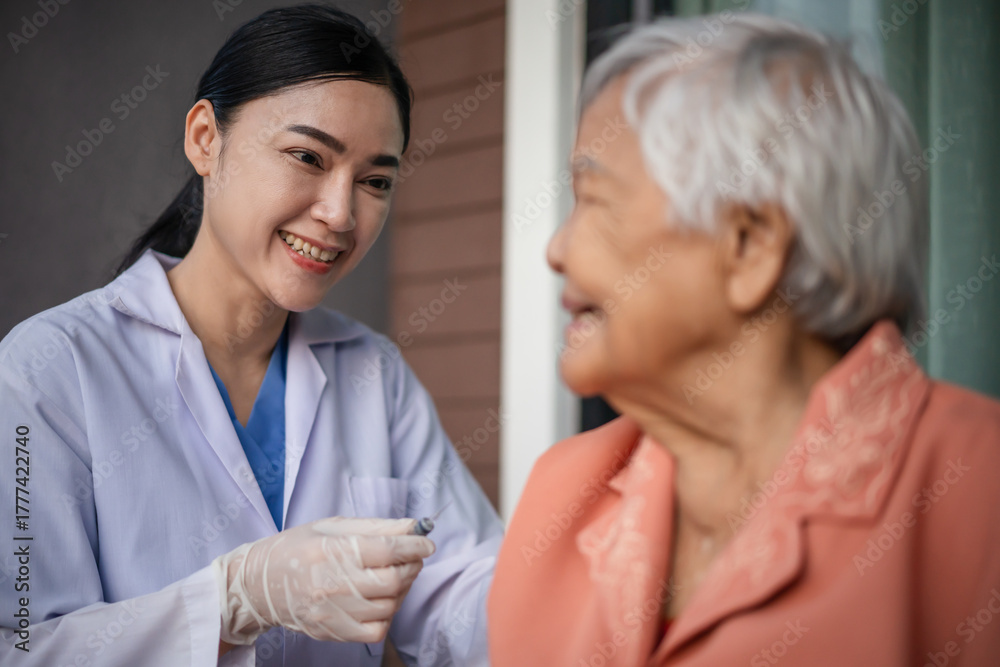 Naklejka premium doctor holding syringe and making injection vaccine to happy senior woman