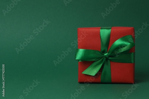Christmas gift box and decorations on green background,  seasonal greeting