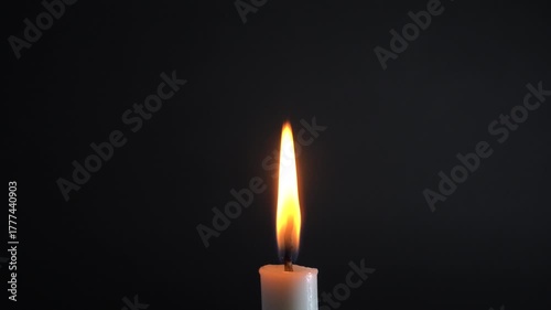 Elegant candle flame flickering gently against dark backdrop creates a peaceful, meditative mood and evokes a sense of warmth and tranquility