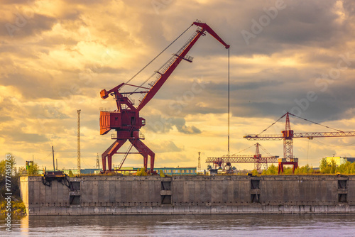 Evening view on red gantry crane at the Lesosibirsk river port on the Yenisei River, Russia. Industrial background