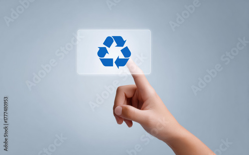 Hopeful person hand with finger pushing virtual button with blue recycle symbol. concept for environmental conservation, technology, and green future on screen
