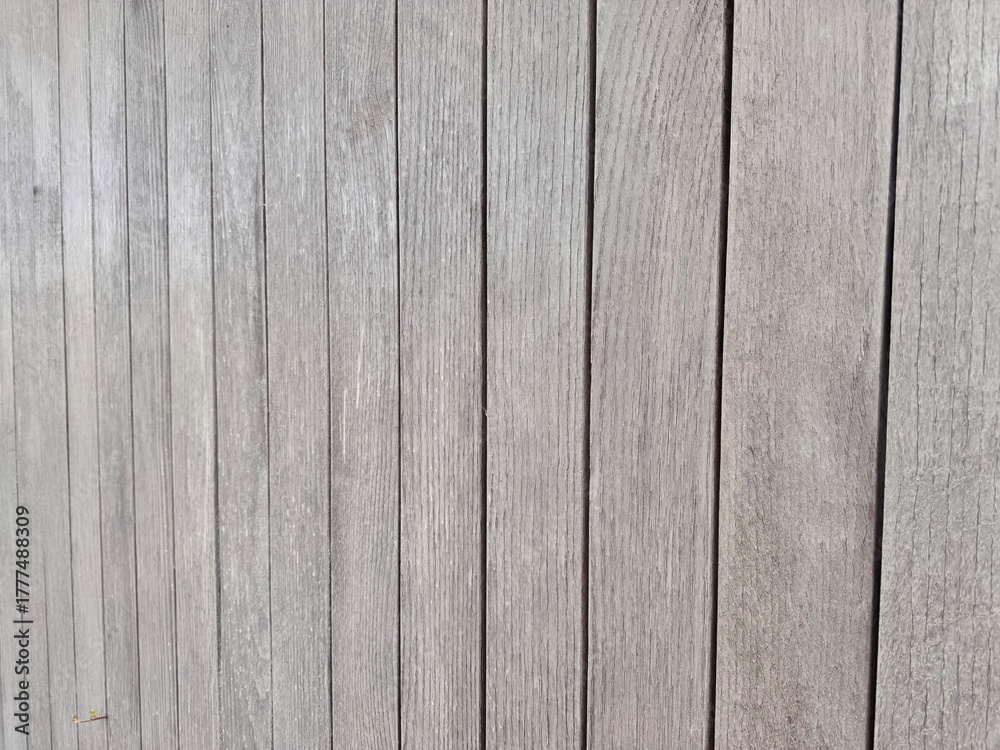 Naklejka premium Wooden planks arranged vertically in a neutral-toned background 