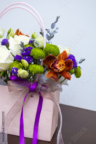 Cropped image of a hand with a craft paper bag with flowers.