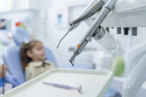 Tapet Pediatric dentistry tools with child patient in background at modern clinic