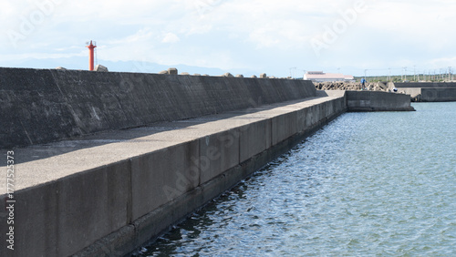 Long Concrete Breakwater under Clear Blue Sky
