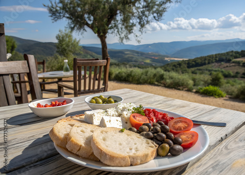 Traditional Mediterranean breakfast plate with feta cheese, olives, tomatoes, and bread, outdoor setting with scenic view, healthy rustic cuisine and travel food concept