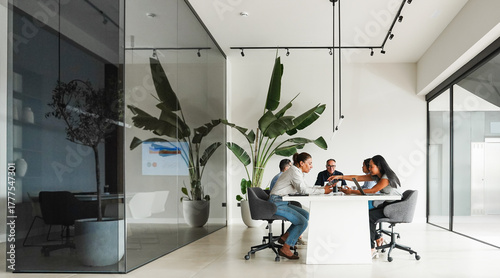 Business people sharing ideas at teamwork meeting inside minimal office - Multiracial colleagues discussing new financial project - Brainstorming and corporate concept - Main focus on left girl face