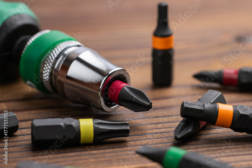 A closeup shot of screwdriver with bits on wooden background