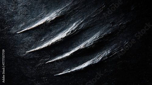 Close-up view of deep, claw-like scratches on a dark, textured surface