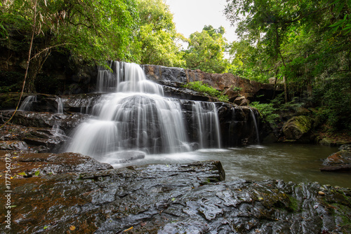 Serene Waterfall Scene: Witness the mesmerizing cascade of water tumbling gracefully over ancient stones, creating a tranquil oasis within a lush green forest, inspiring peace and serenity.