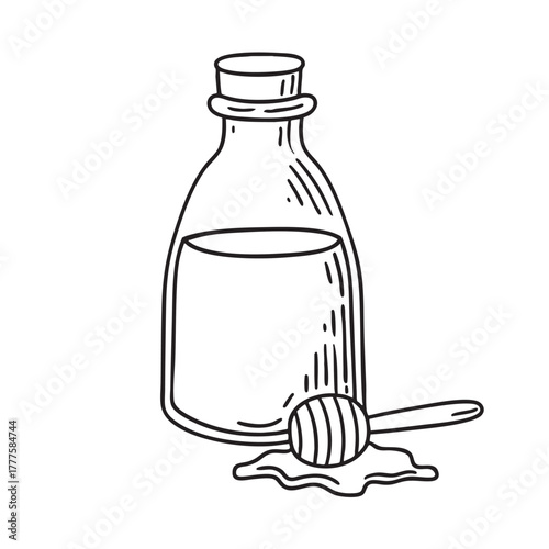 Bottle containing thick dark date syrup served with a wooden dipper