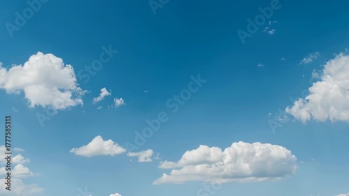 Fluffy white clouds drifting across a clear blue sky. Great for travel ads, meditation videos, environmental education, and relaxation backgrounds.
