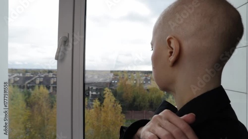 Back view of female cancer patient in thoughtful pose, symbol of hope, awareness, and psychological strength.