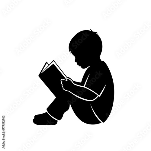 Young child reading a book while sitting quietly on the floor  
