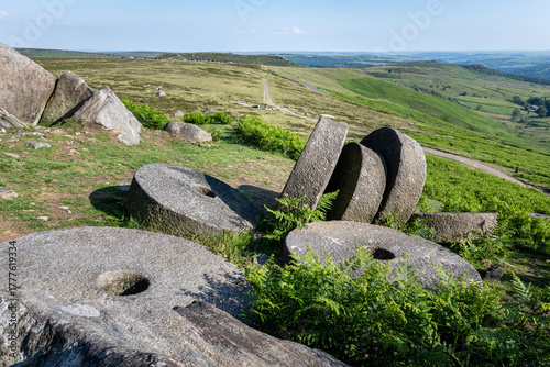 Fotografie Old millstones on hillside landscape at Stanage Edge Peak District Derbyshire