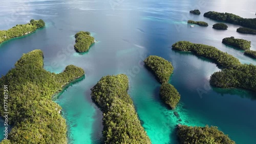 Aerial view of calm blue lagoon surrounded by lush green tropical islands in Raja Ampat, Indonesia.	