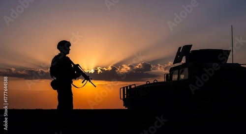 Photo of Contrast Composition of Silhouette of Soldier holding weapon and Fleet of cars next to him in Sunset Atmosphere