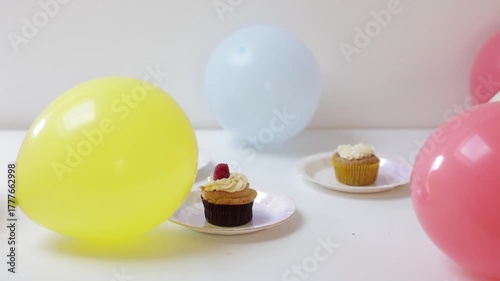 three cup cake with colorful balloons