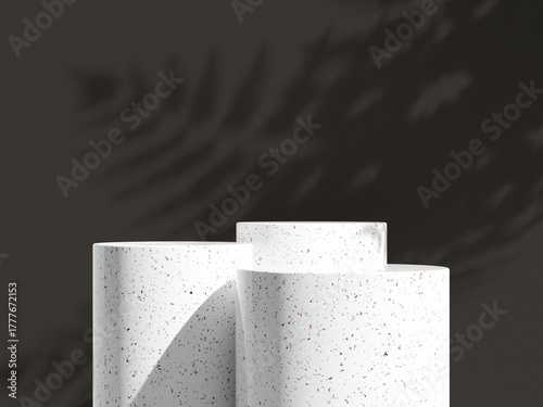 Softly curved granite podium trio with faint shadows against a muted gray wall.
