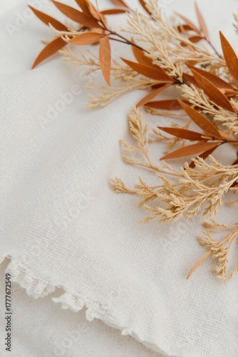 Textured Fabric Swatches and Natural Elements An extreme close up of various natural fabric textures rough linen, soft wool, and woven jute. Interspersed are delicate dried leaves, small smooth