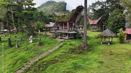 Aerial view of the traditional Tongkonan houses in Ke’te Kesu village, Tana Toraja, Indonesia, surrounded by lush green rice fields.	