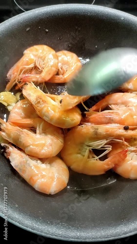 Chef frying king prawns in a pan