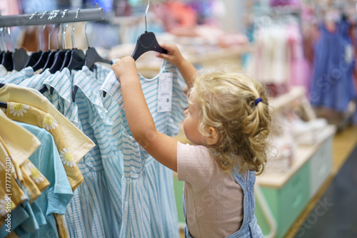 Little girl’s dream of frilly dresses at a cheerful children’s boutique in Summer