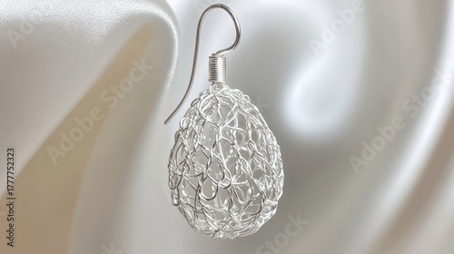 Intricate silver filigree earring against a blurred background