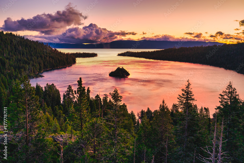 Obraz premium Emerald Bay State Park at Lake Tahoe California USA sunrise view with Fannette Island reflecting calm pink water surrounded by pine forest mountains and dramatic colorful sky scenic nature landscape