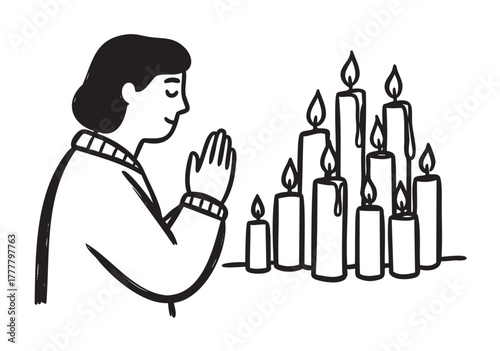 A female with dark hair and closed eyes, in prayer with clasped hands, sits across a group of lit candles draped in wax, evoking a peaceful and contemplative scene.