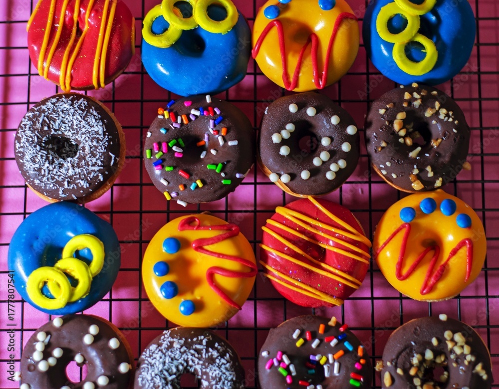 Fototapeta premium mini donas de colores en plano cenital sobre rejilla de enfriamiento