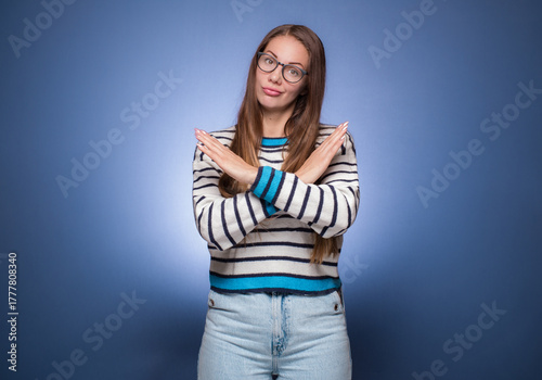Limit. Woman gesturing stop or x sign with her arms, refuses or reject something, girl crossing her hands, isolated on blue background.