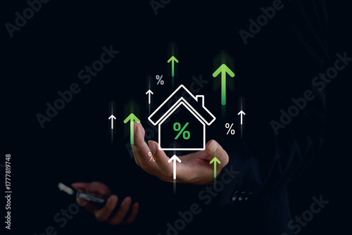 Businessman holding smartphone and digital house icon with percentage and green upward arrows, symbolizing real estate investment, mortgage rate growth, and housing market finance.