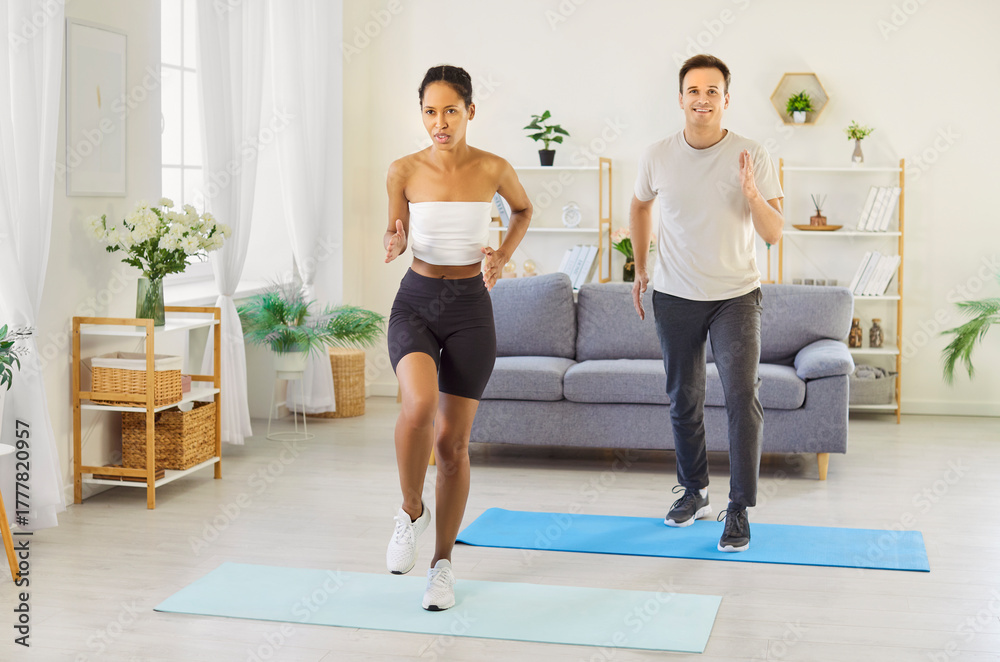 Naklejka premium Couple family workout at home together. They perform cardio exercise on soft mats in a bright living room, training side by side for fitness. Teamwork builds a stronger, healthy bond.