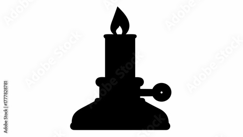 Silhouette of a vintage candle holder with a lit candle on top casting a warm glow in the darkness