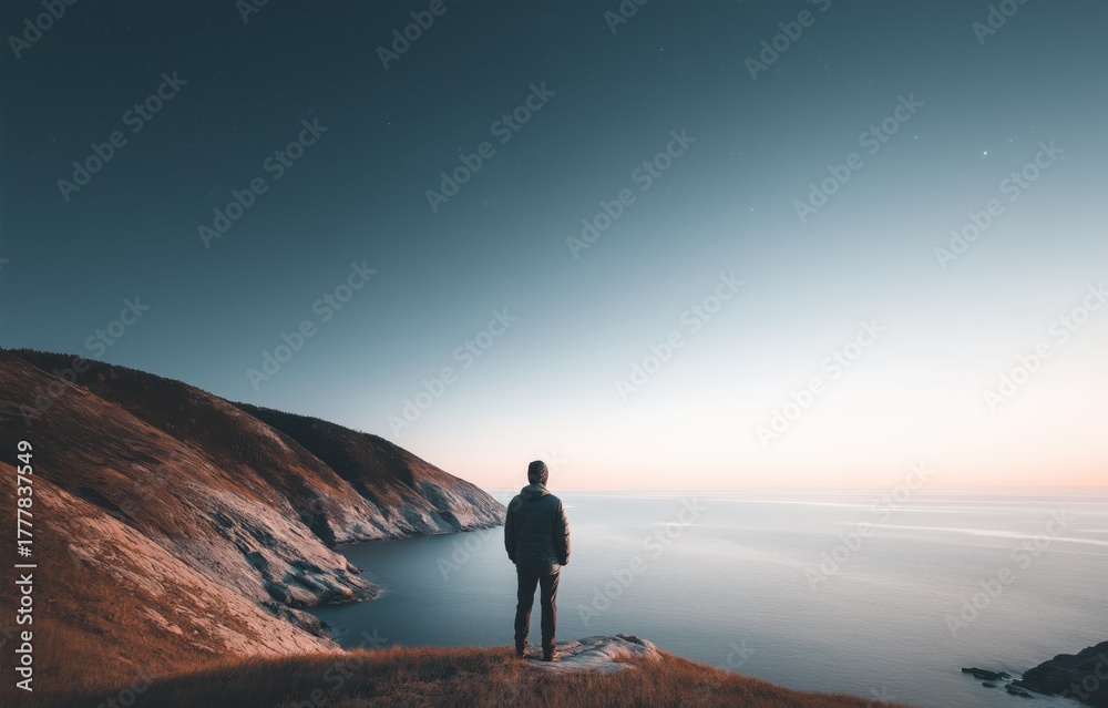 Fototapeta premium Lone figure embracing infinity at tranquil horizon under soft twilight glow over serene ocean vista