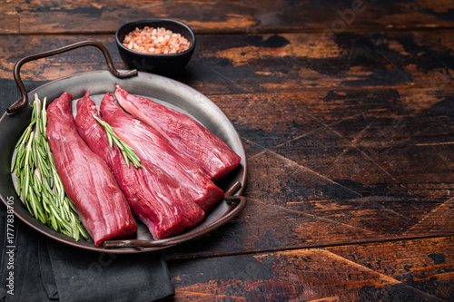 Ready for cooking raw lamb tenderloin fillet meat, fresh loin mutton. wooden background. top view