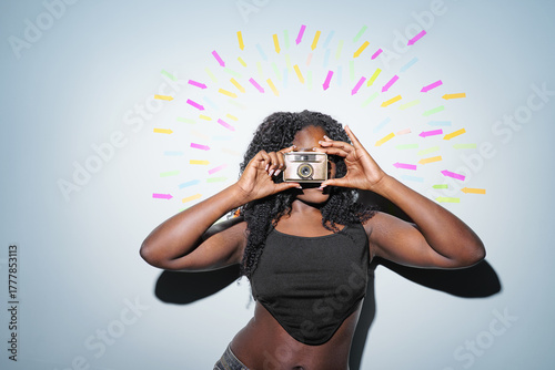 Portrait of a young woman with a retro camera at the center. Arrows in the background point towards the woman. social media, successful, communication concept.