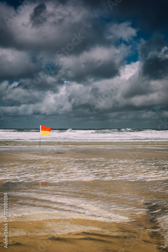 Stormy Beach with Lifeguard Flag on Windy Day, Cornwall Coast