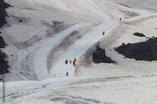 A chain of climbers ascending Mount Elbrus from a height of 4,100 m.