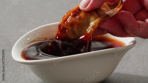 Dip with soy sauce Japanese brown teriyaki sauce in the spoon with circle rotation close up, sweet chilli in fast food restaurant