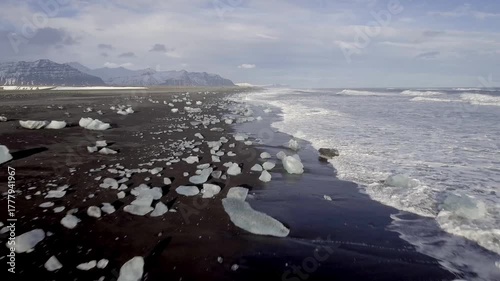 Aerial view of black sand beach with iceberg ice pieces on the shore also called diamond beach