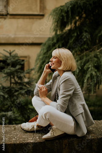 Woman sitting on a wall tal...