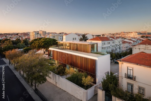 Modern architectural design stands out in a scenic urban landscape during sunset near Lisbon with vibrant colors reflecting off the building's facade