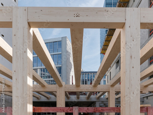 Modern building construction site of a sustainable Timber-concrete composite office building at night with exposed timber beams and structural framework