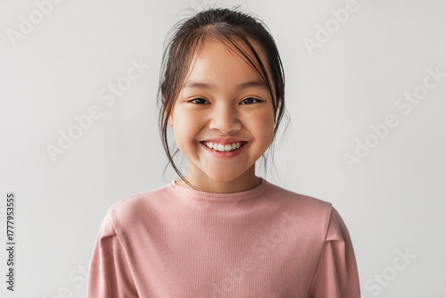Bilde på lerret A toothy Chinese girl smiles brightly while looking directly at the camera