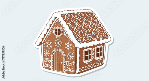 Festive gingerbread house with icing and winterthemed decorations on light background